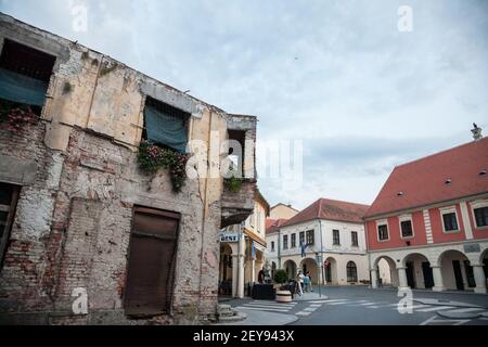 VUKOVAR, KROATIEN - 12. MAI 2018: Beschädigtes Haus mit Einschlägen aus dem Konflikt von 1991 in der Franjo Tudjman Straße, der Hauptstraße von Vukovar, im Norden Stockfoto