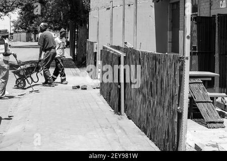 JOHANNESBURG, SÜDAFRIKA - 06. Jan 2021: Johannesburg, Südafrika - 17. Oktober 2016: Afrikanische Arbeiter renovieren die Außenseite von kleinen Spaza s Stockfoto