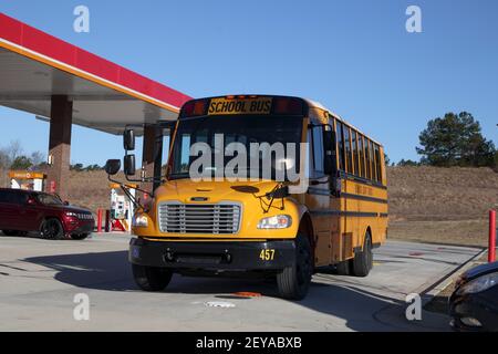 Augusta, GA USA - 03 05 21: Gelber Schulbus im neuen Stil an einer Tankstelle Stockfoto