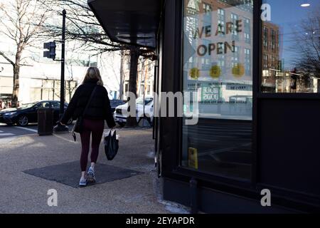 (210306) -- WASHINGTON, 6. März 2021 (Xinhua) -- EINE Frau geht an einem Laden vorbei, in dem ein Schild "Wir sind offen" steht, in Washington, DC, USA, 5. März 2021. US-Arbeitgeber hinzugefügt 379.000 Arbeitsplätze im Februar, mit der Arbeitslosenquote wenig verändert bei 6,2 Prozent, berichtete das Arbeitsministerium am Freitag. Im Februar traten die meisten Arbeitsgewinne in der Freizeit und im Gastgewerbe auf, mit kleineren Gewinnen in der temporären Hilfe, im Gesundheitswesen und in der Sozialhilfe, im Einzelhandel und in der Fertigung, laut dem monatlichen Bericht, der vom Büro für Arbeitsstatistik der Abteilung veröffentlicht wurde. (Foto von Ting Shen/ Stockfoto