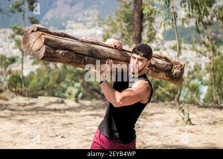 Ein hübscher männlicher Mann, der in der Natur eine riesige hält Protokoll Stockfoto
