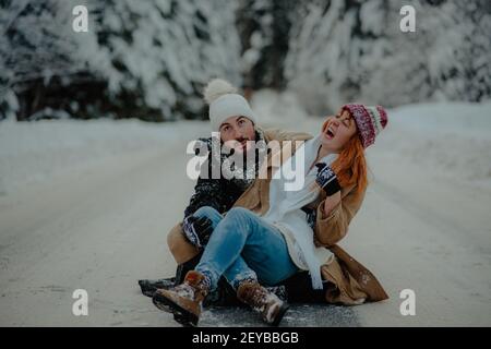 Ein schönes Paar mit verrückten Mimik und unkontrollierbar lachen Freundin teilt ihre Liebe, während sie auf dem Boden sitzt Stockfoto