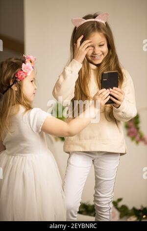 Zwei kleine Mädchen mit Handys. Freundschaft Konzept glücklich kleine Mädchen unter Selfies mit Smartphone Stockfoto