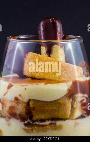 Nahaufnahme eines traditionellen italienischen süßen Tiramisu-Kuchendessert im Glas auf grauem Hintergrund. Kopierbereich. Menü, Rezept Stockfoto