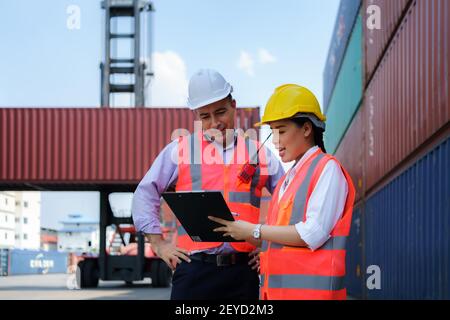 Asiatische Arbeitnehmerin erklärt dem Vorgesetzten im Container-Depot-Terminal eine Checkliste für Containerinspektionen. Stockfoto