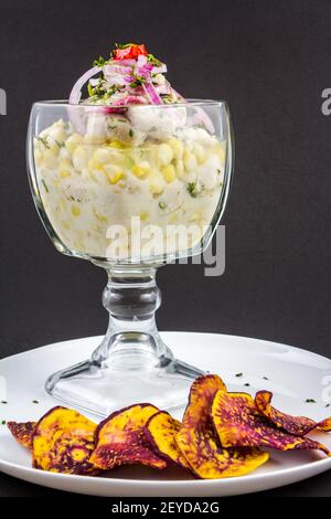Peruanische Meeresfrüchte: Fisch Cebiche mit Zwiebel, Chili, Mais und Süßkartoffeln auf einem weißen Teller serviert Stockfoto