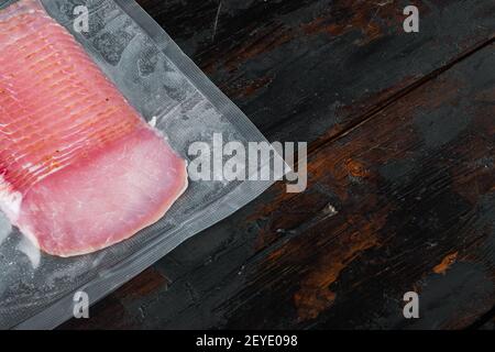 Balyk, Schweinehauch-Schinken-Set, vakuumverpackt, auf altem dunklen Holztischhintergrund, mit Platz für Text Stockfoto