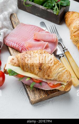 Classic BLT Croissant Sandwiches Set, mit Kräutern und Zutaten, auf weißem Stein Hintergrund Stockfoto