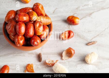 Reife Früchte von kultivierten Eleagnus (Silberbeere) Pflanzen. Die nussgroße braune Frucht hat eine dünne Haut. Nach dem Abschälen der halbsüßen Flavory, pudrige te Stockfoto