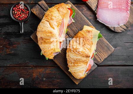 Klassisches BLT Croissant Sandwiches Set, mit Kräutern und Zutaten, auf altem dunklen Holztisch Hintergrund, Draufsicht flach Lay Stockfoto