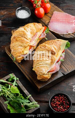 Klassisches BLT Croissant Sandwiches Set, mit Kräutern und Zutaten, auf altem dunklen Holztisch Hintergrund Stockfoto