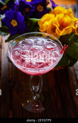 Kosmopolitischer Cocktail garniert mit Eis auf Holztisch Stockfoto