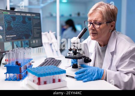 Pharmacy Senior Scientist arbeitet mit professionellen Mikroskop in der Klinik Entdeckung. Modernes Labor mit Forschungsgeräten für Virusstudien und Impfstoffforschung Stockfoto