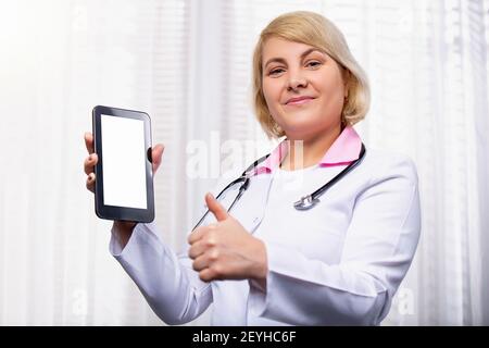 Intellektuelle Gesundheitswesen professionelle kaukasischen Arzt mit digitalen weißen leeren Raum Tablette auf weißem Hintergrund. Doktor gestikuliert Daumen nach oben. Stockfoto