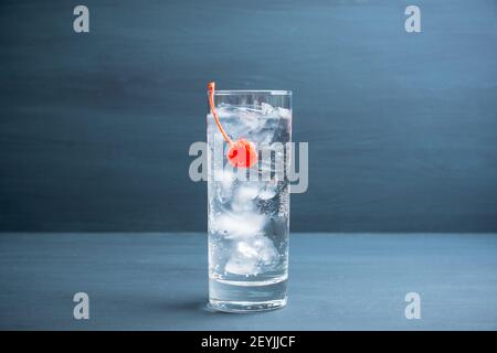 Bitter transparenter Cocktail mit Cocktailkirsche. Selektiver Fokus. Geringe Schärfentiefe. Stockfoto