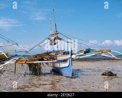 Wartungsarbeiten an einem traditionellen Fischerboot mit Stützen in Tinoto, einem Fischerdorf in Maasim, Provinz Sarangani auf den Philippinen Stockfoto