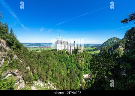 Blick auf das berühmte und erstaunliche Schloss Neuschwanstein, Bayern, Deutschland, von der Marienbrücke aus gesehen, einer Fußgängerbrücke über eine Klippe Stockfoto