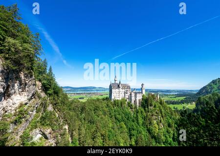 Blick auf das berühmte und erstaunliche Schloss Neuschwanstein, Bayern, Deutschland, von der Marienbrücke aus gesehen, einer Fußgängerbrücke über eine Klippe Stockfoto