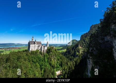 Blick auf das berühmte und erstaunliche Schloss Neuschwanstein, Bayern, Deutschland, von der Marienbrücke aus gesehen, einer Fußgängerbrücke über eine Klippe Stockfoto