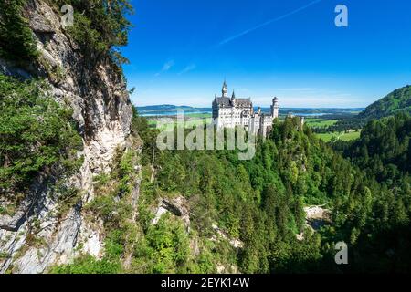 Blick auf das berühmte und erstaunliche Schloss Neuschwanstein, Bayern, Deutschland, von der Marienbrücke aus gesehen, einer Fußgängerbrücke über eine Klippe Stockfoto