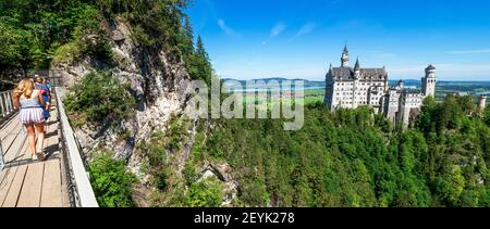 Blick auf das berühmte und erstaunliche Schloss Neuschwanstein, Bayern, Deutschland, von der Marienbrücke aus gesehen, einer Fußgängerbrücke über eine Klippe Stockfoto