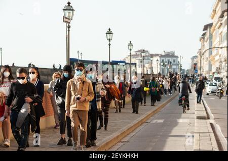 Florenz, Italien - 2021. Februar 21: Menschen auf dem Radweg, Radfahren entlang des Flusses Arno und Wandern auf dem Bürgersteig. Stockfoto