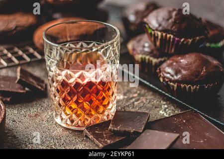 Whiskey auf einem Hintergrund von Schokolade Donuts und der Schokolade. Stockfoto