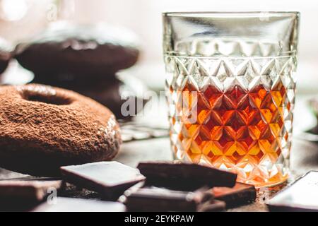 Whiskey auf einem Hintergrund von Schokolade Donuts und der Schokolade. Stockfoto