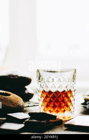 Whiskey auf einem Hintergrund von Schokolade Donuts und der Schokolade. Stockfoto