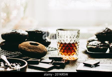 Whiskey auf einem Hintergrund von Schokolade Donuts und der Schokolade. Stockfoto