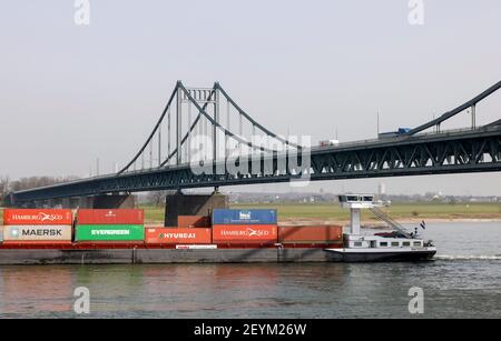 Krefeld, Nordrhein-Westfalen, Deutschland - Frachtschiff überquert den Rhein unter der Krefeld-Uerdingen-Brücke am Rheinhafen Krefeld. Stockfoto