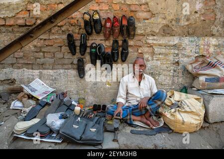 Howrah, Indien - Februar 2021: Ein Mann repariert Schuhe auf der Straße am 5. Februar 2021 in Howrah, Westbengalen, Indien. Stockfoto