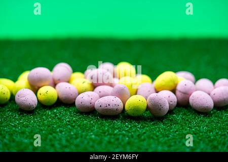 Bunte gelbe und rosa osterei mit Sommersprossen Muster auf Gras Stockfoto