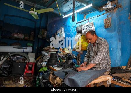 Kolkata, Indien - Februar 2021: Ein Schneider arbeitet mit einer Nähmaschine in seiner Werkstatt am 4. Februar 2021 in Kolkata, Westbengalen, Indien. Stockfoto