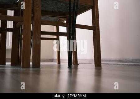 Beine aus Holzstuhl und Tisch im Vintage- und Retro-Stil. Tischbeine aus Metall. Alle bleiben sie auf Holzboden mit Sonnenschein von den Fenstern. Stockfoto