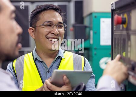 Nahaufnahme des Technikers oder Elektrikers, der arbeitet, prüfen Sie das elektrische System mit dem Tablet im Werk. Stockfoto