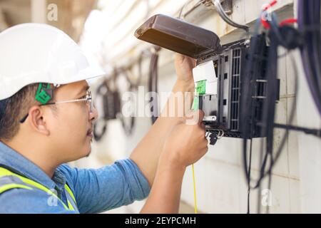 Techniker reparieren Anschluss die Fasern auf Splitter-Fach Nahaufnahme außen Stockfoto