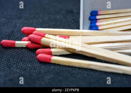 Eine Nahaufnahme von roten und blauen Spitzen Holzpappen verstreut Auf der dunklen Oberfläche Stockfoto