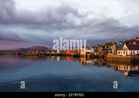 Morgenlicht mit Vintage-Häusern am Wasser auf Orkney Island in nordschottland mit blauem Wasser und hellem Himmel über der Ferne Hügel Stockfoto