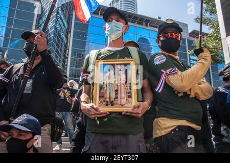 Bangkok, Thailand. März 2021, 06th. Ein Protestant, der ein Porträt von König Maha Vajiralongkorn (Rama X) und Königin Suthida während der Demonstration hält.Pro-royalistische Anhänger von König Maha Vajiralongkorn protestieren vor dem Central World Einkaufszentrum und fordern Schutz für die Monarchie. Kredit: SOPA Images Limited/Alamy Live Nachrichten Stockfoto