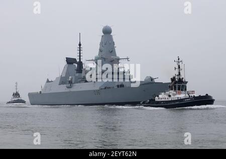 Die Schlepper SD BOUNTIFUL und SD INDULGENT eskortieren den Royal Navy Daring Klasse Zerstörer HMS DEFENDER in Richtung der Hafeneinfahrt Stockfoto