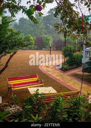 Bunte gestreifte Bänke in einem Garten Stockfoto