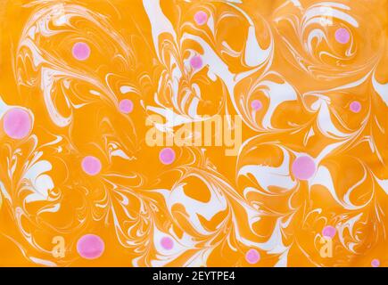 Abstrakt marmorieren ebru bunte orange Hintergrund mit Wellen und rosa Blots Stockfoto