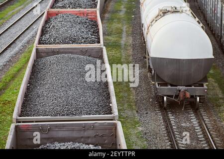 Eisenbahn-Güterwagen mit Kohle beladen. Güterzug transportiert Kohle, Holz, Brennstoff. Draufsicht. Stockfoto