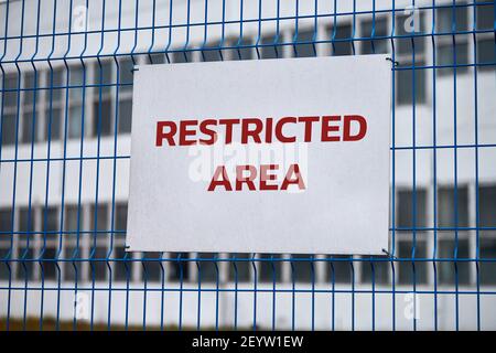 Eingeschränkter Bereich, nur autorisiertes Personal – Sicherheitswarnung kein Übertretungszeichen. Rote Buchstaben, Warnung auf Metallzaun fernhalten, Umrandungssymbol. Stockfoto