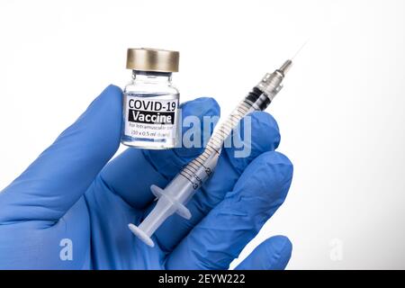 Nahaufnahme der Hand mit Operationshandschuh mit Covid-19-Impfstofffläschchen Stockfoto