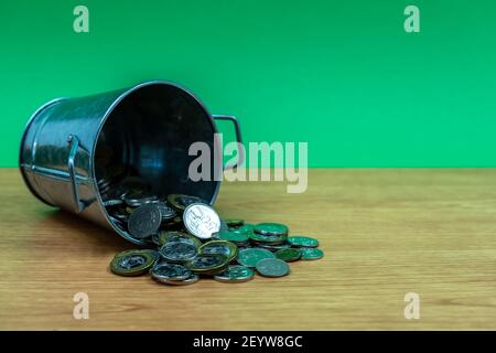 Singapur Dollar Silbermünzen verschüttet aus Silber Eimer. Isoliert. Stockfoto