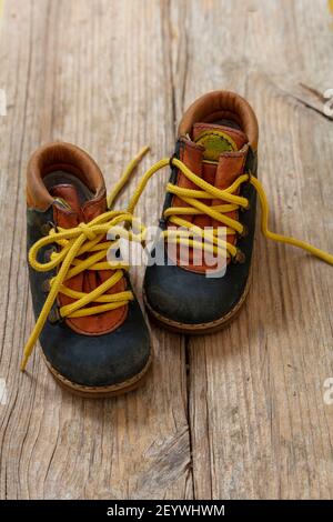 Baby Junge kleine Größe Booties Nahaufnahme Ansicht. Kid Kleinkind Schuhe blau Farbe Leder mit gelben unbanden Schuh Schnürsenkel auf Holzboden. Stockfoto