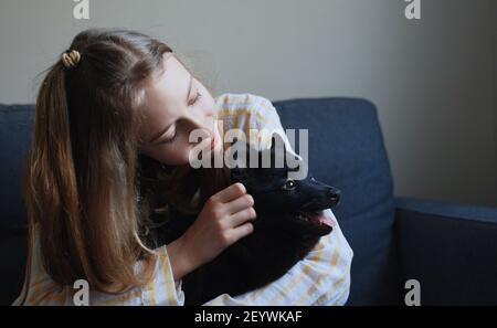 Tween Mädchen spielen mit Welpen zu Hause. Stockfoto