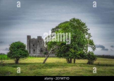 Ruinen der alten Bective Abbey aus dem 12th. Jahrhundert mit grünen Bäumen, Weide und launisch dunklen Himmel im Hintergrund, County Meath, Irland Stockfoto